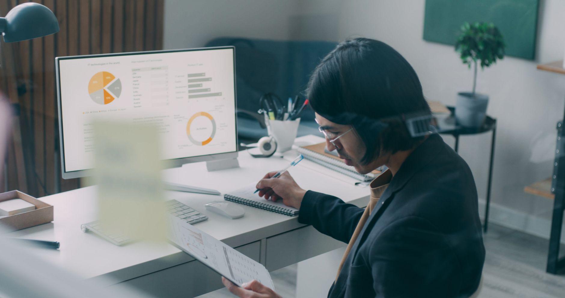 Business person reviewing analytics and charts at a modern office desk.
